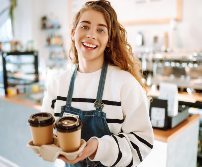 Funding for a growing London Cafe The happy barista holding two cups of coffee in a growing café